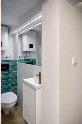 a white bathroom with a toilet and a sink at MIYABI Apartment in Kraków