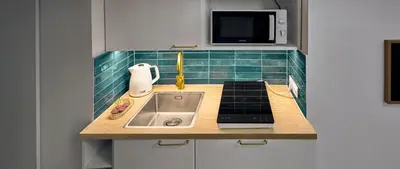 a small kitchen with a sink and a microwave at MIYABI Apartment in Kraków