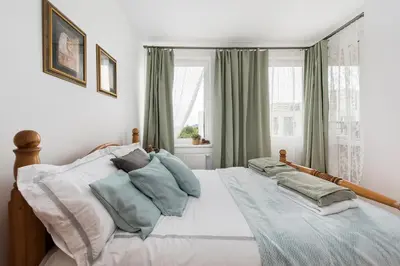a bedroom with a large bed with green curtains at Jasmine's apartment in Kraków
