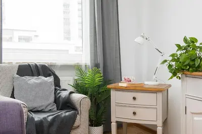 a living room with a chair and a table with a lamp at Jasmine's apartment in Kraków