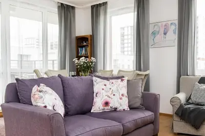 a living room with a purple couch with two pillows at Jasmine's apartment in Kraków