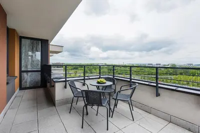 a balcony with a table and chairs and a view at Jasmine's apartment in Kraków