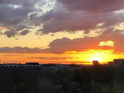 a sunset over a city with the sun setting at Jasmine's apartment in Kraków