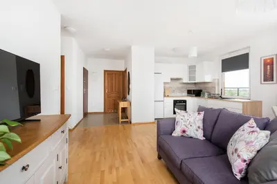 a living room with a purple couch and a kitchen at Jasmine's apartment in Kraków