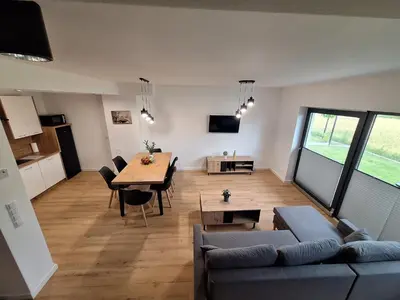 a kitchen and dining room with a table and chairs at Magic Apartments - Zatoria in Zator