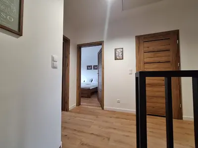 a living room with a couch and a staircase at Magic Apartments - Zatoria in Zator