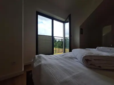 a bedroom with a bed and a large window at Magic Apartments - Zatoria in Zator