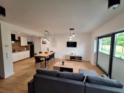 a hallway with a wooden door and a living room at Magic Apartments - Zatoria in Zator