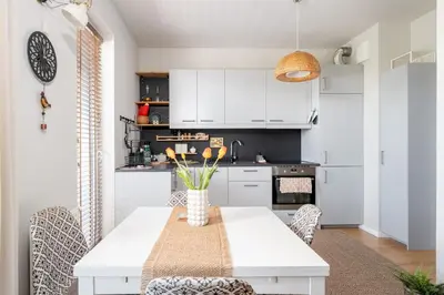 a kitchen and dining room with a white table and chairs at Przewóz Charming Nest Apartment by BookingHost in Kraków