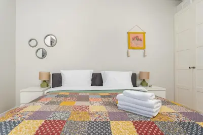 a bedroom with a bed with a colorful quilt at Przewóz Charming Nest Apartment by BookingHost in Kraków