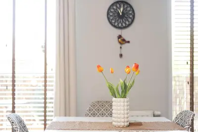 a vase with flowers on a table in a dining room at Przewóz Charming Nest Apartment by BookingHost in Kraków