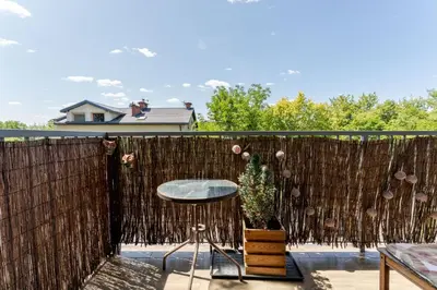 a fence with a table and a chair on a patio at Przewóz Charming Nest Apartment by BookingHost in Kraków