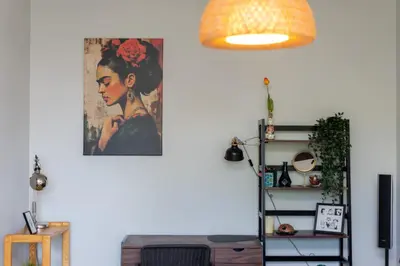 a living room with a painting on the wall and a shelf at Przewóz Charming Nest Apartment by BookingHost in Kraków