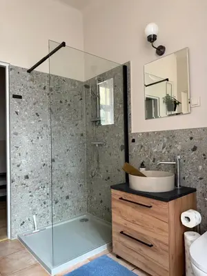 a bathroom with a shower with a sink and a mirror at Szlak Loft in Kraków