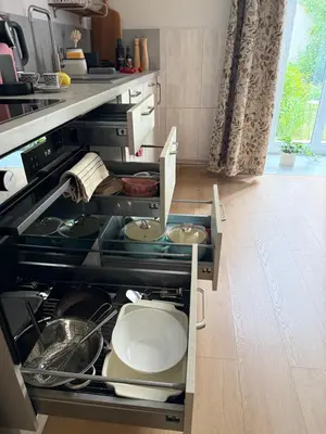 a kitchen with an open drawer with pots and pans at Szlak Loft in Kraków