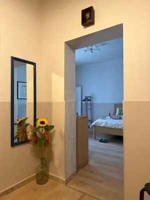 a room with a mirror and a vase with flowers at Szlak Loft in Kraków