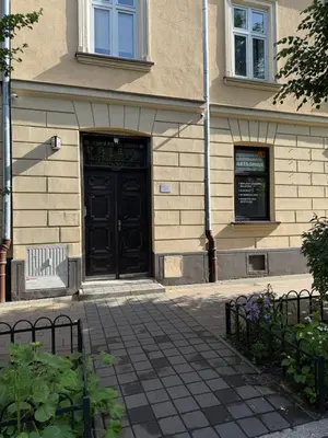 a building with a black door on a sidewalk at Szlak Loft in Kraków