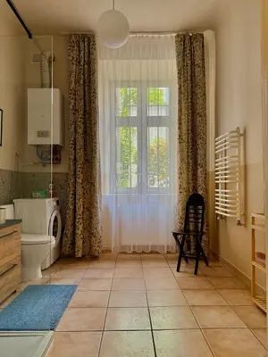 a bathroom with a toilet and a window at Szlak Loft in Kraków