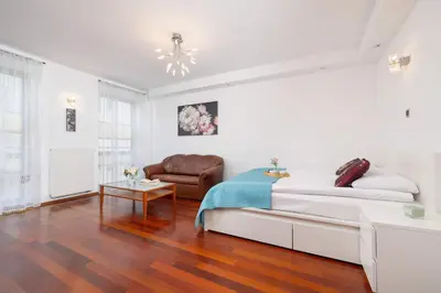 a white bedroom with a bed and a chair at Krupnicza Family Studio with AC Quiet Krakow Old Town by Noclegi Renters in Kraków