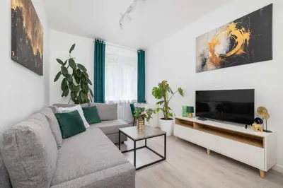 a living room with a couch and a flat screen tv at Bright Two-Bedroom Apartment in Nowa Huta by Noclegi Renters in Kraków