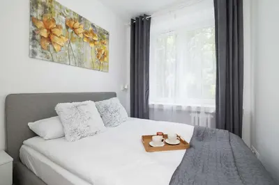a bedroom with a bed with a tray on it at Bright Two-Bedroom Apartment in Nowa Huta by Noclegi Renters in Kraków