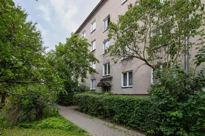 a large white building with a sidewalk next to it at Bright Two-Bedroom Apartment in Nowa Huta by Noclegi Renters in Kraków