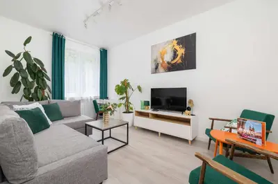 a living room with a couch and a tv at Bright Two-Bedroom Apartment in Nowa Huta by Noclegi Renters in Kraków