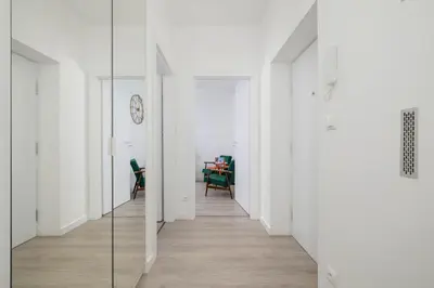 a hallway with white walls and a glass wall at Bright Two-Bedroom Apartment in Nowa Huta by Noclegi Renters in Kraków