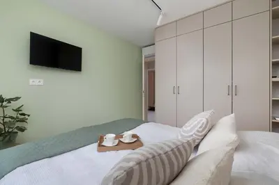 a bedroom with a bed with a tv on the wall at Family Apartment with Air Conditioning with 3 Bedrooms in Cracow by Noclegi Renters in Kraków