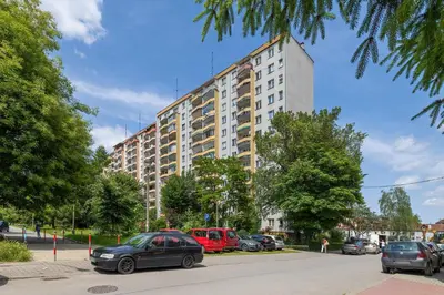 a large building with cars parked in a parking lot at Family Apartment with Air Conditioning with 3 Bedrooms in Cracow by Noclegi Renters in Kraków