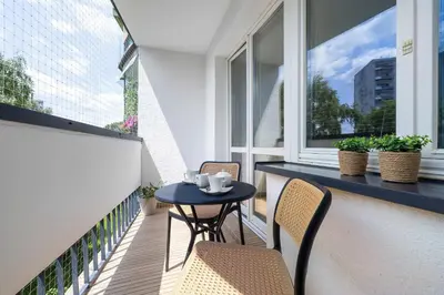 a balcony with a table and chairs and windows at Family Apartment with Air Conditioning with 3 Bedrooms in Cracow by Noclegi Renters in Kraków