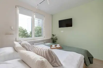 a white bedroom with two beds and a window at Family Apartment with Air Conditioning with 3 Bedrooms in Cracow by Noclegi Renters in Kraków