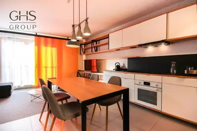 a kitchen with a dining room table and chairs at Ekskluzywny apartament, Browar Lubicz, FREE Parking in Kraków