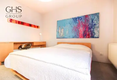 a bedroom with a white bed and a painting on the wall at Ekskluzywny apartament, Browar Lubicz, FREE Parking in Kraków