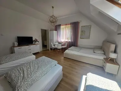 a living room with two beds and a table at Pod Różą in Rząska