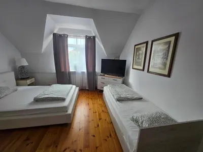 a bedroom with two beds and a television in it at Pod Różą in Rząska