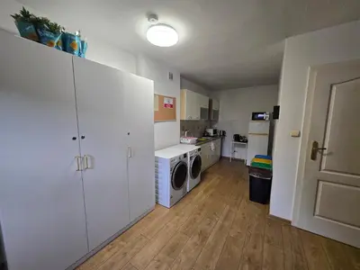 a kitchen with white cabinets and a washer and dryer at Pod Różą in Rząska