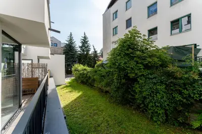 a garden with a bench next to a building at Riverside Comfort Apartment by BookingHost in Kraków