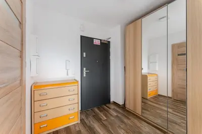 a bedroom with a closet and a dresser and a mirror at Riverside Comfort Apartment by BookingHost in Kraków