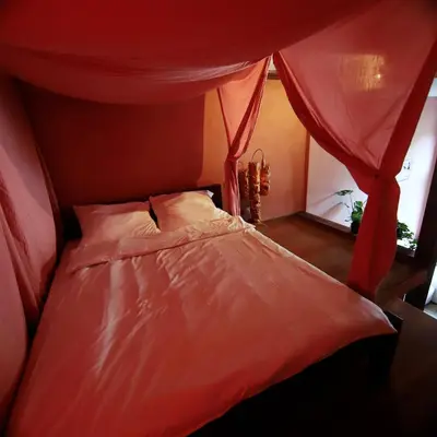 a bed with a red canopy in a bedroom at Rose & Thyme Artisan Studio in Old Town in Kraków