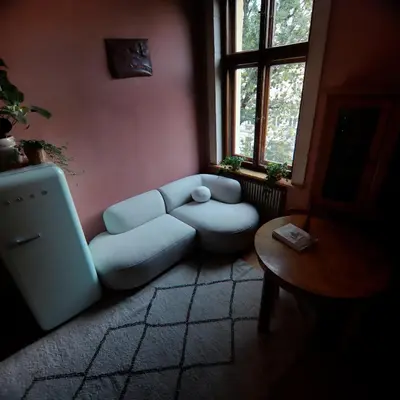 a living room with a blue couch and a table at Rose & Thyme Artisan Studio in Old Town in Kraków