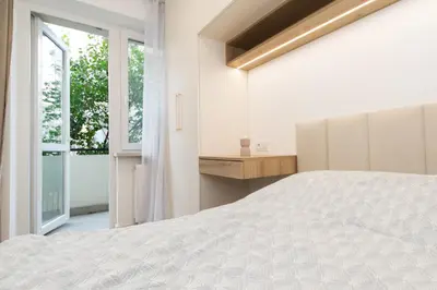 a bedroom with a white bed and a window at Cozy Flat with a Garden in Kraków
