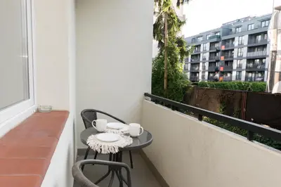 a small table on a balcony with two chairs at Cozy Flat with a Garden in Kraków