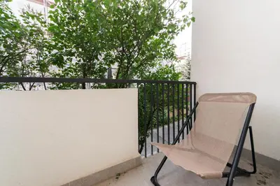 a chair sitting on a balcony next to a wall at Cozy Flat with a Garden in Kraków