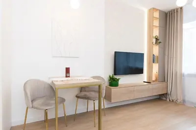 a living room with a table and a tv at Cozy Flat with a Garden in Kraków