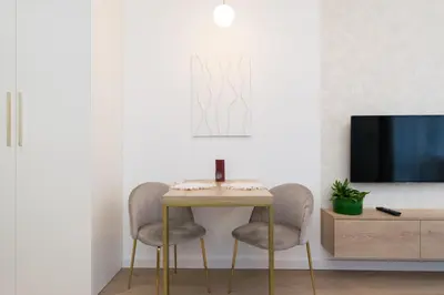 a living room with a table and two chairs and a tv at Cozy Flat with a Garden in Kraków
