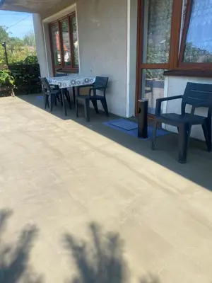 a patio with two benches and a table and chairs at Pokoje Pod Lasem