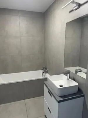 a bathroom with a sink and a mirror and a tub at Apartament ,nocleg, wysoki standard in Niepołomice