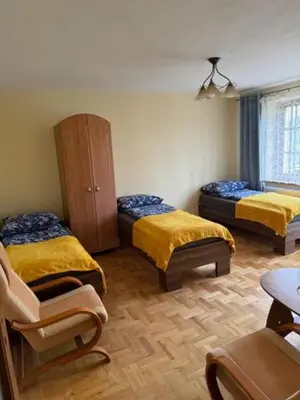 a room with two beds and a cabinet and a chair at Bochnia ,nocleg, pokoje, kwatery pracownicze,dom in Bochnia