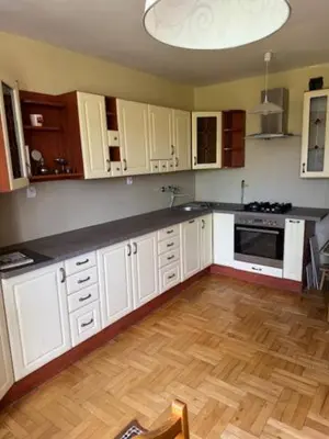 a kitchen with white cabinets and a wooden floor at Bochnia ,nocleg, pokoje, kwatery pracownicze,dom in Bochnia